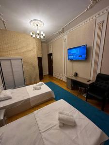 YakkasarayにあるNext hotel Tashkentのベッド2台、薄型テレビが備わるホテルルームです。