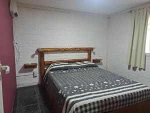 a small bedroom with a bed in a room at Complejo Las Palmeras Casa 1 in San Clemente del Tuyú
