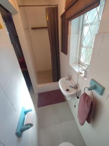 a bathroom with a sink and a toilet and a mirror at Paradise in the City Cottage Two in Port Elizabeth