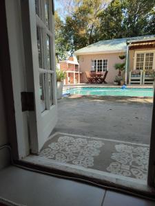 eine offene Tür zu einem Garten mit Pool in der Unterkunft Paradise in the City Cottage Two in Port Elizabeth