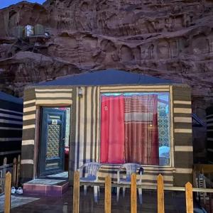 a house on the stage with a table and chairs at Panorama camp jeep trips in Wadi Rum