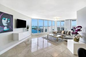 sala de estar con sofá y TV en Pisces Dream - Direct water views!, en Miami