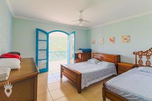 a bedroom with two beds and an open door at Linda casa de fazenda no interior de SP in Elias Fausto