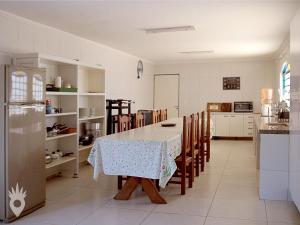uma cozinha com uma mesa e cadeiras e um frigorífico em Linda casa de fazenda no interior de SP em Elias Fausto