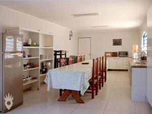 a kitchen with a table and chairs and a refrigerator at Linda casa de fazenda no interior de SP in Elias Fausto