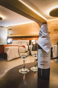 dos copas de vino sentadas en una mesa con una botella de vino en Altipacha Ayacucho Hotel en Ayacucho