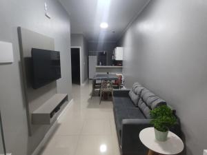 sala de estar con sofá, TV y mesa en Dunas Residence - Casa 10, en Santo Amaro