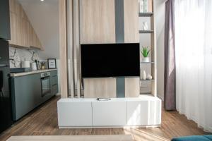 uma sala de estar com televisão num centro de entretenimento branco em NOMAD Apartments em Niš