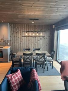 un comedor con mesas y sillas y un sofá en Ski in/out, amazing views, 3 bedrooms, en Noresund
