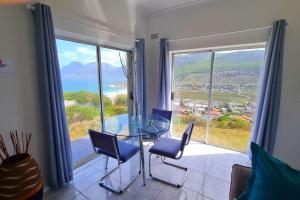 a dining room with a glass table and chairs at SeaViews Holiday Apartment 1 in Cape Town