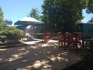 a patio with tables and chairs and an umbrella at Hostal de Luz in Villarrica