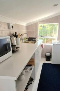 a kitchen with a white counter and a microwave at SeaViews Holiday Apartment 1 in Cape Town