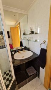 a bathroom with a sink and a mirror at SeaViews Holiday Apartment 1 in Cape Town