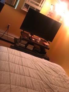 een flatscreen-tv op een bed bij Dream Room in Malba