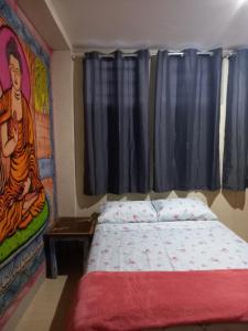 a bedroom with a bed with a painting on the wall at Hostel Trilhas e Rotas - a 150m da Avenida Paulista in São Paulo