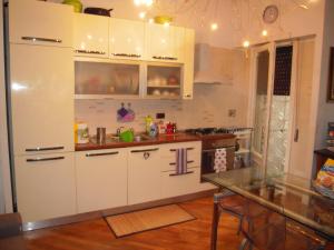 cocina con armarios blancos y mesa en Cassia Home, en Roma