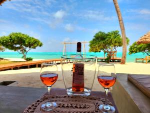due bicchieri di vino seduti su un tavolo vicino alla spiaggia di Almas Beach Boutique Hotel a Makunduchi