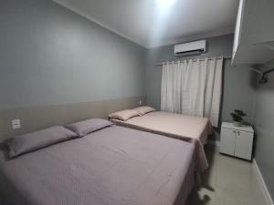 2 camas en una habitación pequeña con ventana en Dunas Residence - Casa 10, en Santo Amaro