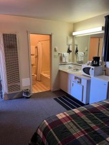 a hotel room with a sink and a bathroom at Bluebird Motel in Claresholm