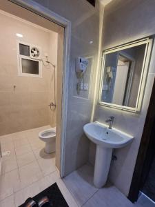 a bathroom with a sink and a toilet at عنوانك للشقق المخدومة in Abha