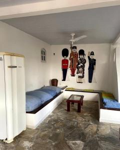 a bedroom with two beds and paintings on the wall at Casa Flamboyant Buzios in Búzios
