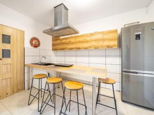 a kitchen with a counter with stools and a refrigerator at Gościnnie Lublin - Olimp in Lublin