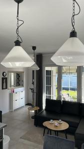 a living room with a black couch and two large lights at Rodzinne miejsce in Kopalino