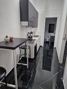 een keuken met zwarte en witte tegelvloeren en een aanrecht bij Black and White 17 in Barletta