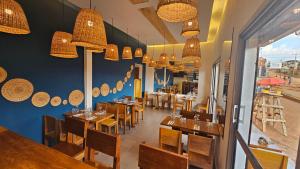 a restaurant with wooden tables and chairs and chandeliers at Nandy's home in Odza II