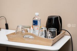 a wooden tray with bottles and glasses on a table at Kendi's Inn Self Catering Apartments in Jwaneng