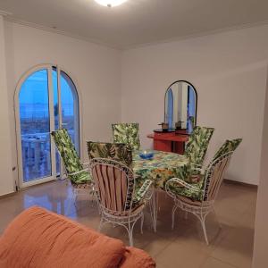 - une salle à manger avec une table, des chaises et un miroir dans l'établissement Παραθαλάσσια εξοχική κατοικία, à Vasilika