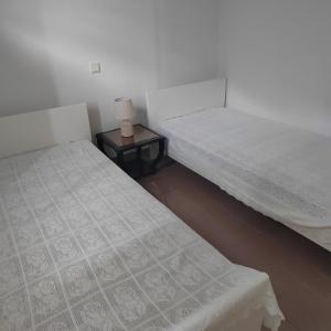 two beds in a room with a side table at Παραθαλάσσια εξοχική κατοικία in Vasilika