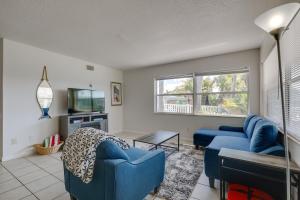 a living room with a blue couch and a tv at Florida Condo with Intracoastal Waterway Views! in Clearwater Beach