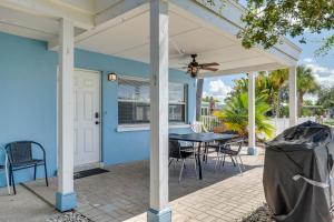 Cette maison bleue dispose d'une terrasse avec une table et des chaises. dans l'établissement Florida Condo with Intracoastal Waterway Views!, à Clearwater Beach