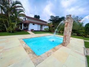 a swimming pool with a water fountain in a yard at Cabaña amplia con piscina, naturaleza y cercana in Los Santos
