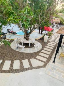 a tree in a garden next to a pool at Blue Sand House B&B in Cartagena de Indias