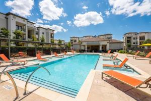 a large swimming pool with lounge chairs and condos at Luxe 2B/2B Getaway - Pool, Gym, Garage, Pet Wash in Leander