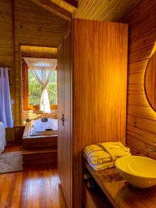 ein Badezimmer mit einem Waschbecken und einer Badewanne in der Unterkunft Chalé Vale das Pedras in Praia Grande