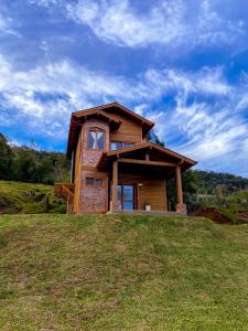 a house sitting on top of a grass field at Chalé Vale das Pedras in Praia Grande