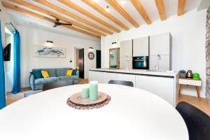 eine Küche und ein Wohnzimmer mit einem Tisch und Stühlen in der Unterkunft Casa Rosa 1 in Rovinj