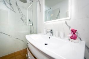 une salle de bain blanche avec un lavabo et un miroir dans l'établissement Casa Rosa 1, à Rovinj 16 autres photos