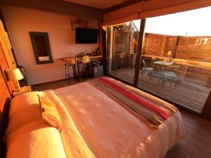 a bedroom with a large bed and a balcony at Esfera Pichilemu - Lodge in Pichilemu