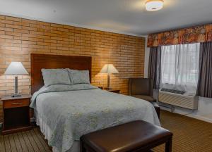 1 dormitorio con cama y pared de ladrillo en Sweet Home Inn, en Sweet Home
