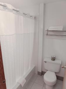 a white bathroom with a toilet and a bath tub at Sweet Home Inn in Sweet Home
