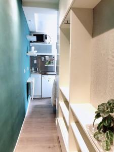 a kitchen with white cabinets and a counter top at Green cozy studio au cœur de Paris in Paris