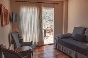 a living room with a couch and a sliding glass door at Hotel Tàrbena in Tárbena