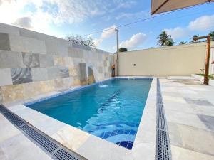 a swimming pool in the middle of a house at Casa Deluxe 2 Maragogi in Maragogi