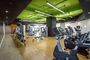 a gym with treadmills and ellipticals in a building at Ocean Views from balcony Walk to Beach and Mall 3024 in Honolulu