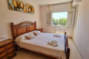 a bedroom with a bed with two towels on it at Piso en el centro con vistas al mar y balcón in Roses