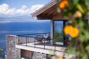 a house with a balcony with a view of the water at Lava Homes in Santo Amaro